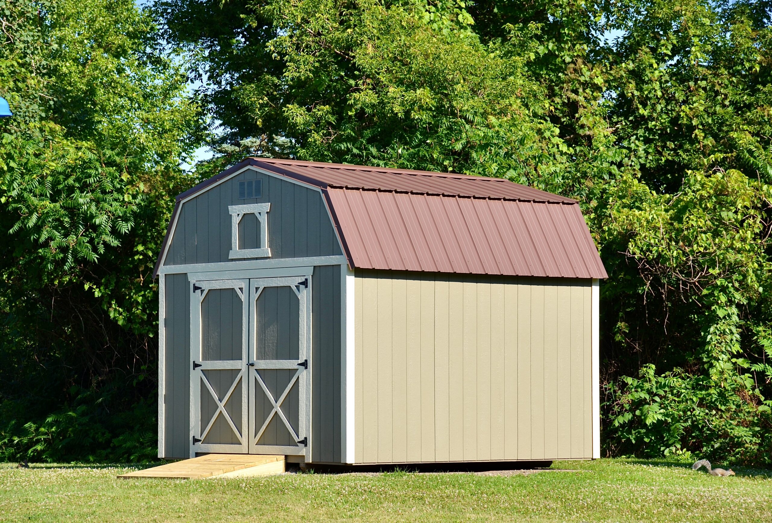 A tan storage shed in a backyard