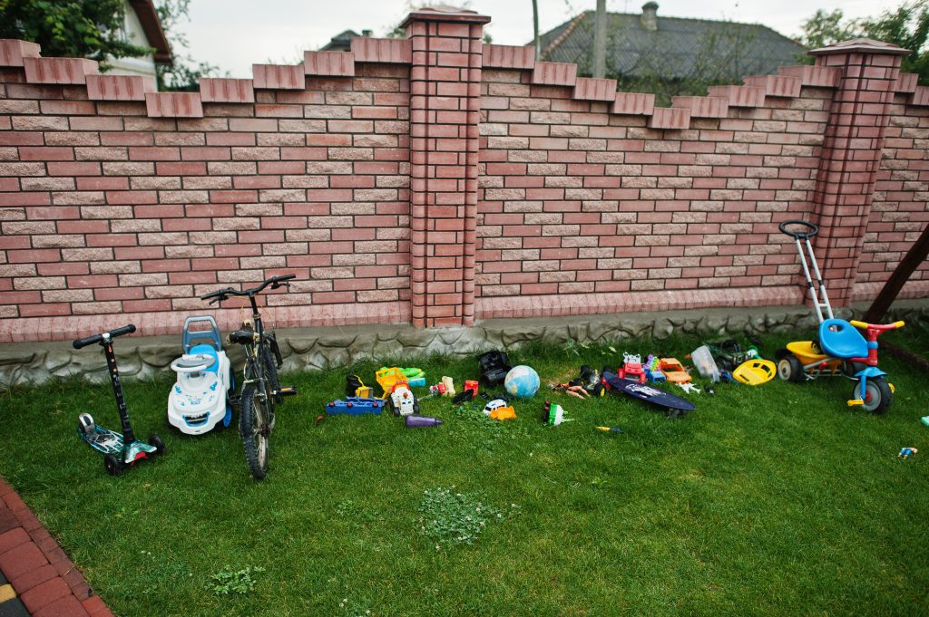 A backyard full of bicycles and toys.